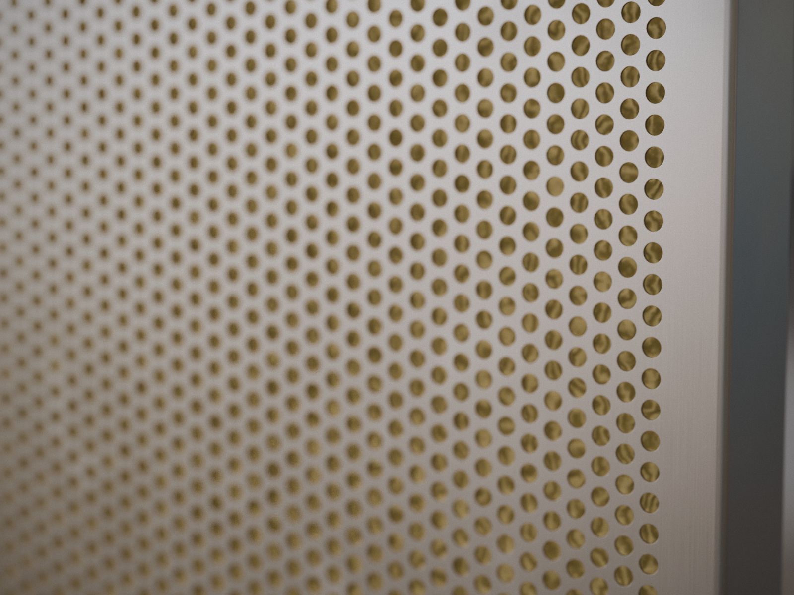 Detalle de la perforación y la lana mineral de un panel acústico
