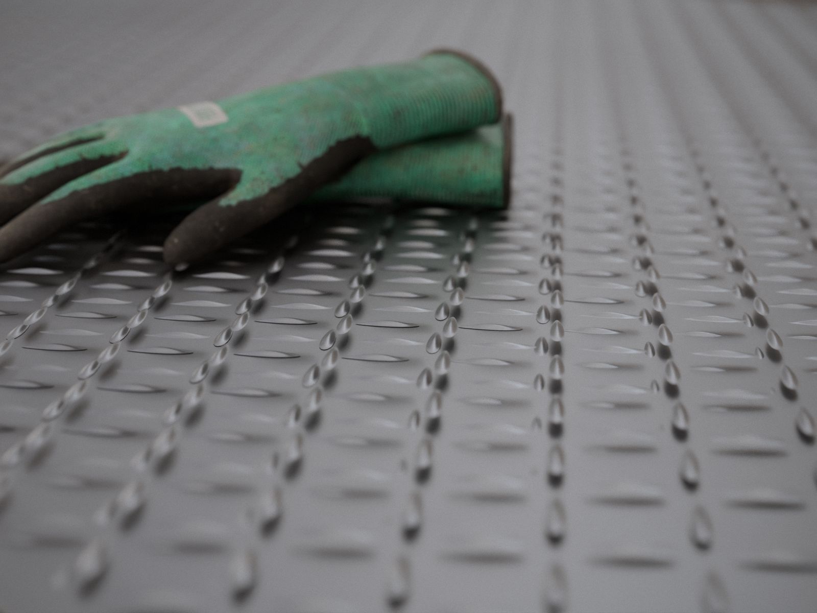 Relieve de lágrima de una plancha estriada con guantes de trabajo