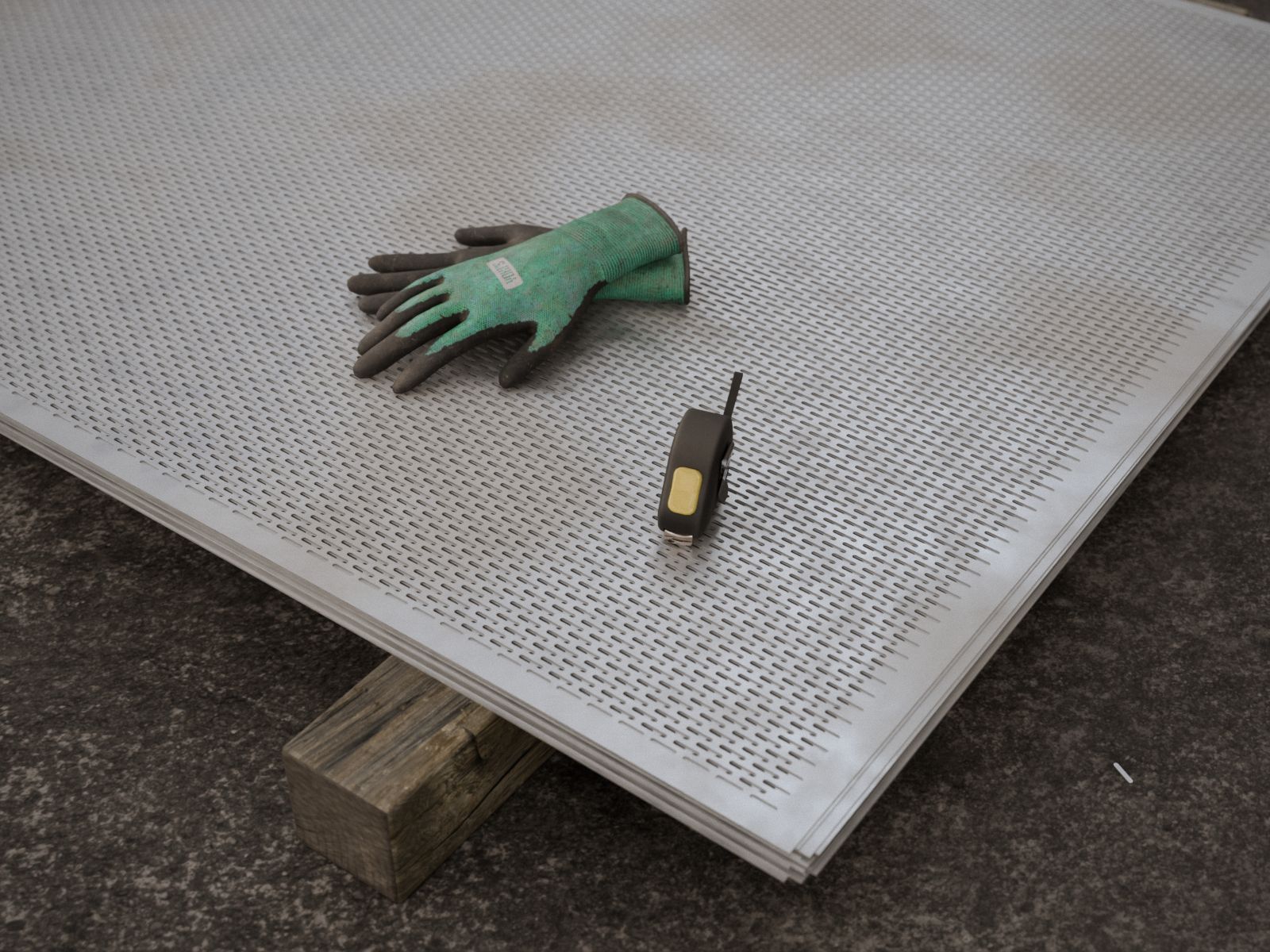 Pila de planchas galvanizadas con oblongos, wincha y guantes