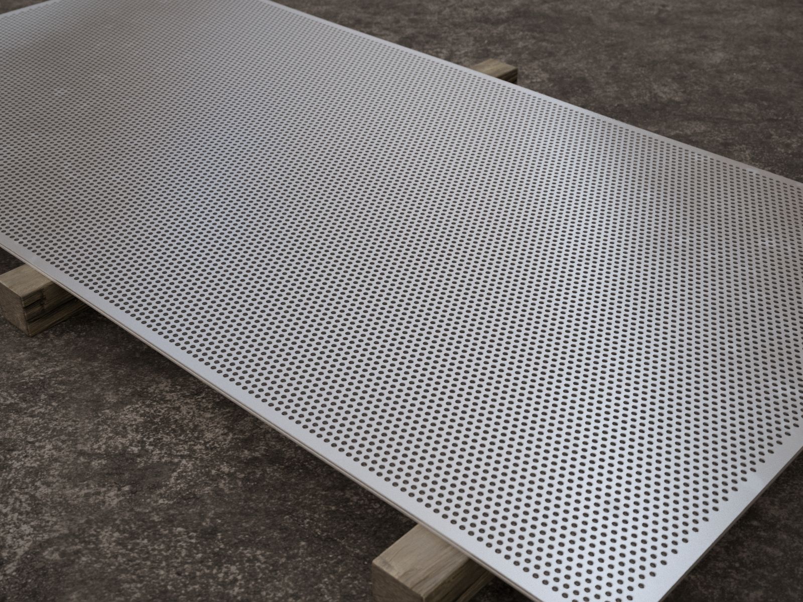 Planchas inoxidables perforadas a pedido, junto a una carretilla